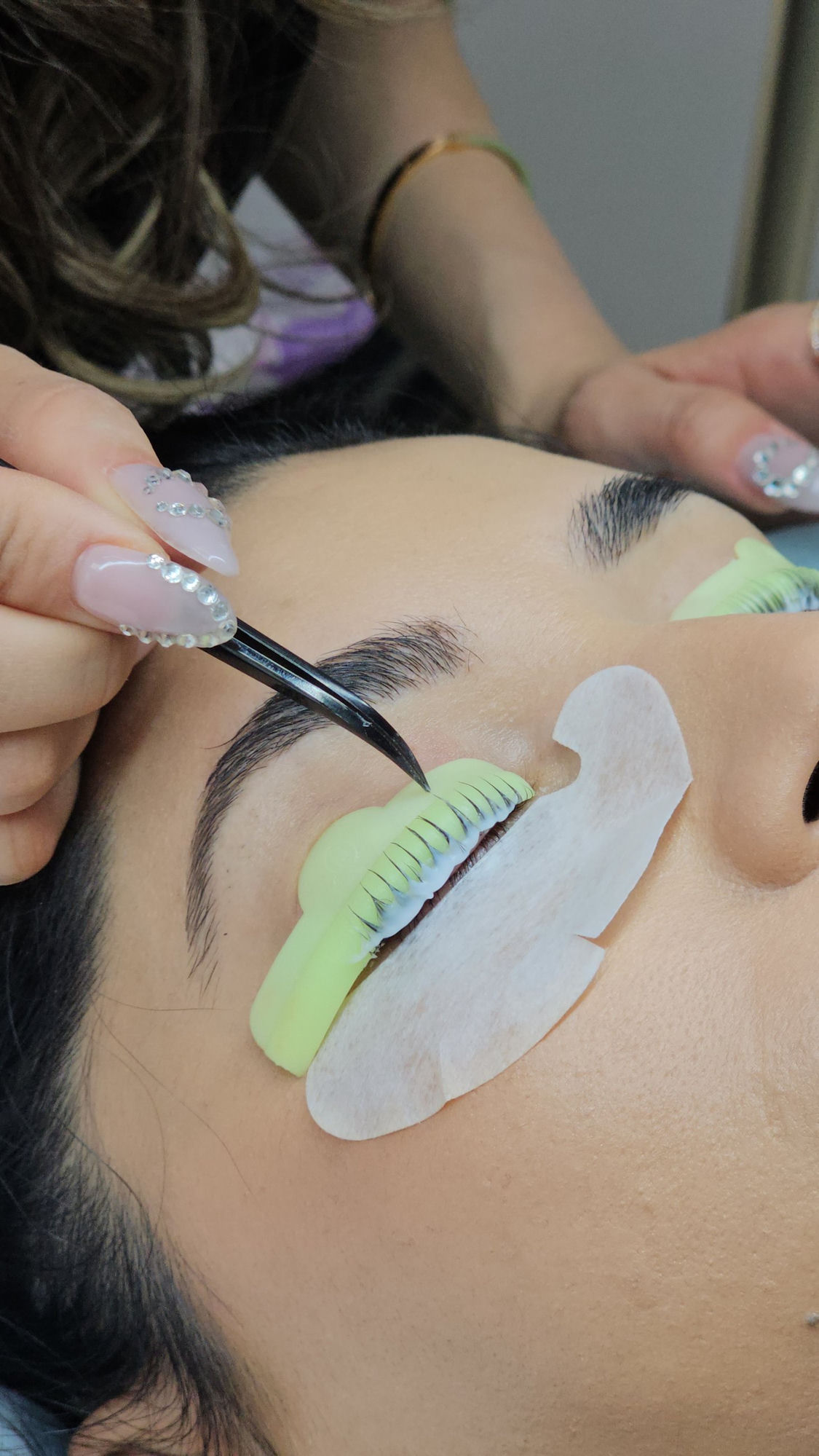 Lash extension treatment in progress.